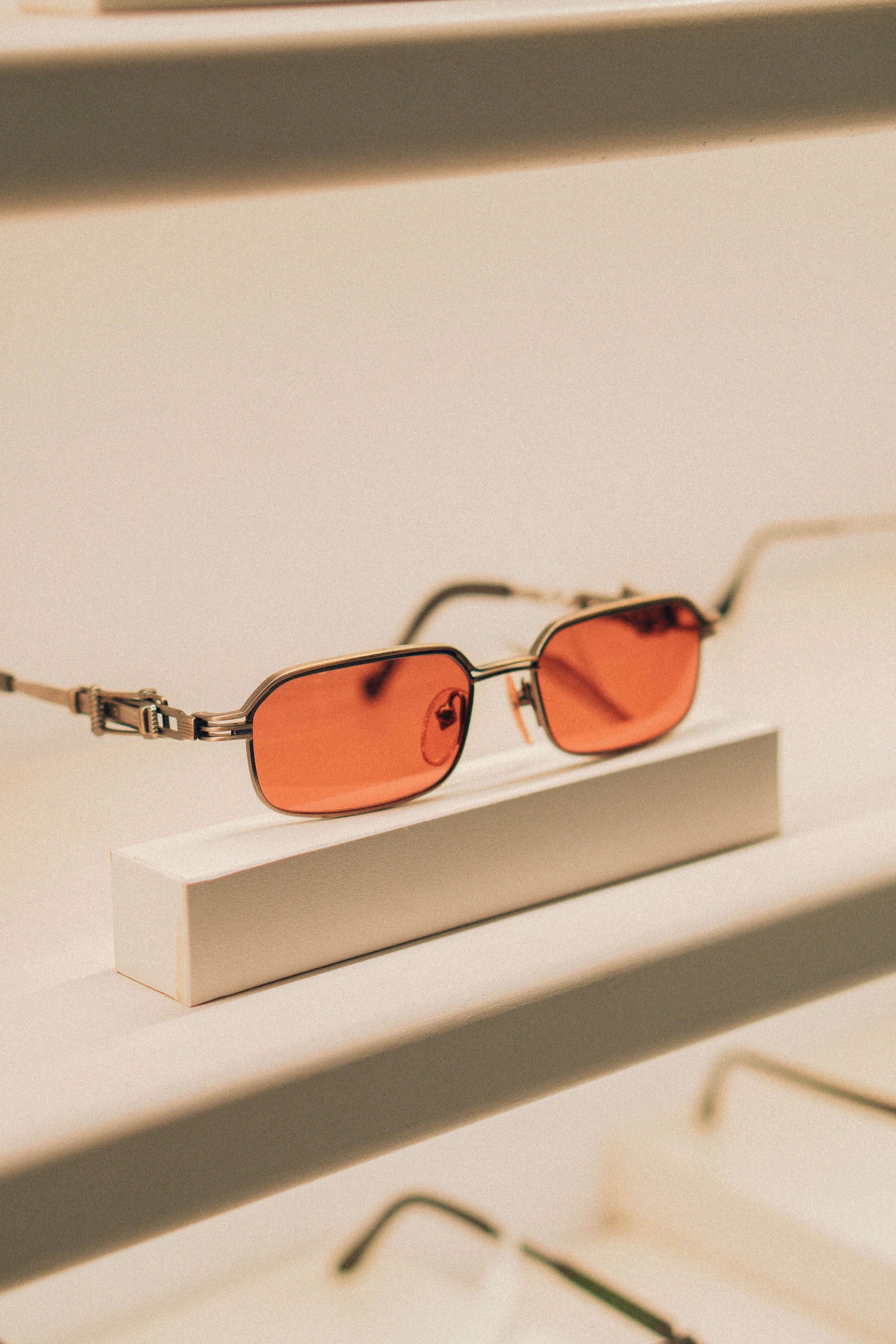 Armações de óculos em acetato tartaruga destacadas sobre base clara na loja.