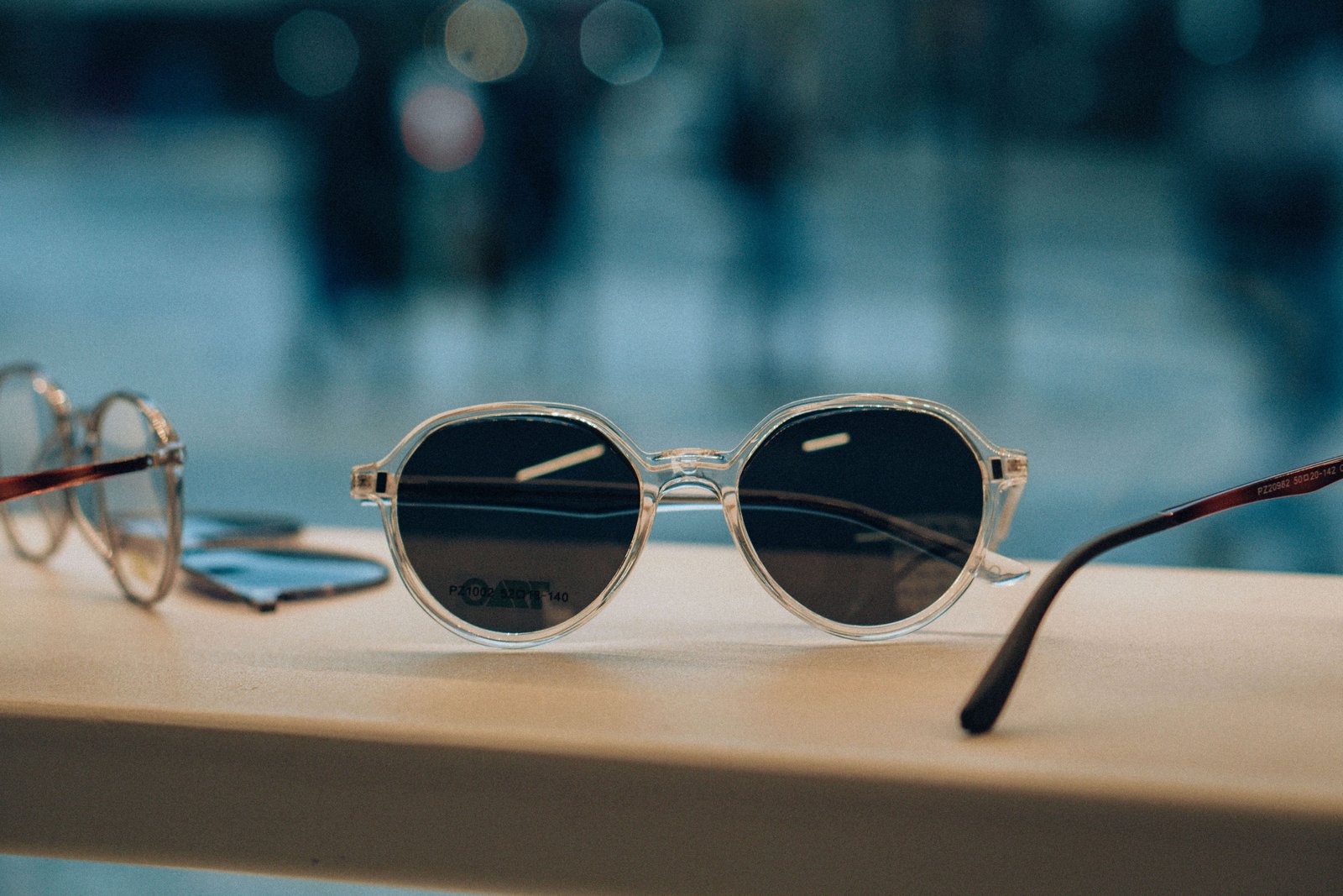 Close de armações de óculos com hastes trabalhadas em metal dourado.