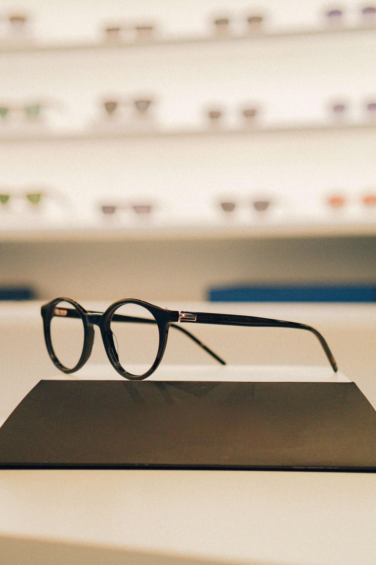 Armações redondas em metal fino com acabamento fosco expostas em linha.